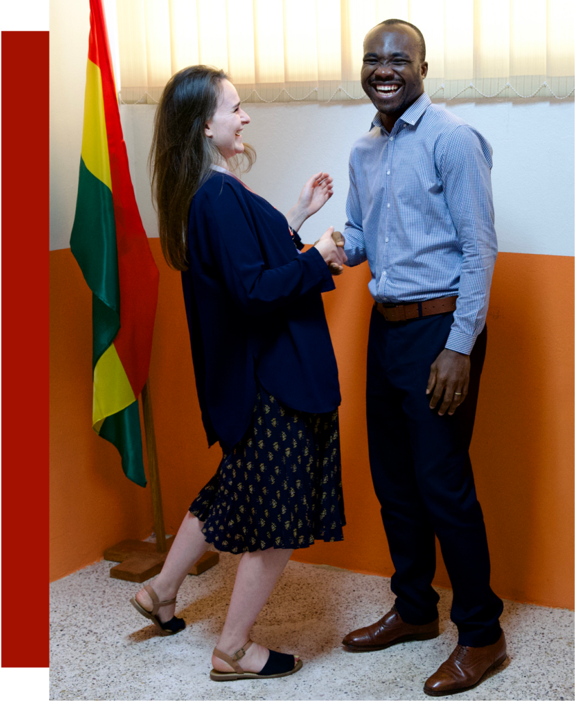 This image shows two people from Germany and Ghana smiling and shaking hands