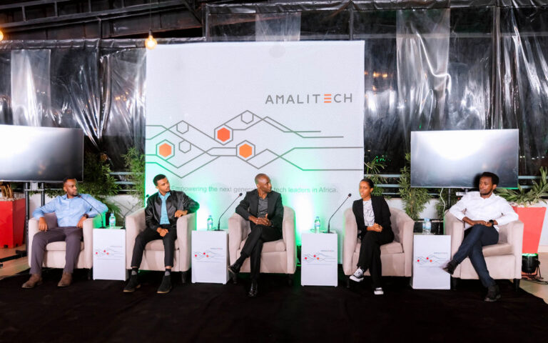 Five panelists seated on the AmaliTech event podium, engaging with the audience.