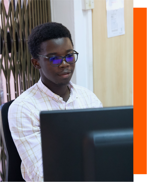 A developer in spectacles gazing at his monitor with a warm expression.